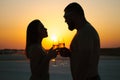 Silhouette of a couple with glasses on sunset background, man and woman clanging wine glasses with champagne at sunset dramatic sk Royalty Free Stock Photo