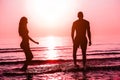 Silhouette of couple having fun inside ocean at sunset - Lovers having tender moments summer vacation - Holidays, relationship and Royalty Free Stock Photo