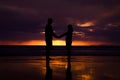 Silhouette of couple hold each other hand and Happy Young Couple love on the beach at sunset time Royalty Free Stock Photo