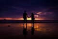 Silhouette of couple hold each other hand and Happy Young Couple love on the beach at sunset time Royalty Free Stock Photo