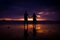 Silhouette of couple hold each other hand and Happy Young Couple love on the beach at sunset time Royalty Free Stock Photo