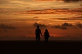 Silhouette of a couple holding hands on a beach at dusk Royalty Free Stock Photo