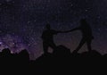 Silhouette of couple holding hands beneath the stars, Milky Way and a lot of stars over the mountain at Wadi Rum desert.