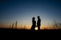 Silhouette of Couple hugging on Power lines background on sunset. Save the planet and electricity. Humanity and Royalty Free Stock Photo