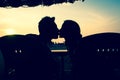 Silhouette of couple kissing while sitting on a shack by the beach at sunset Royalty Free Stock Photo