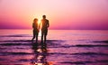 Silhouette of couple in love running inside ocean water at sunset - Lovers having tender moments summer vacation - Holidays, Royalty Free Stock Photo