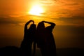 Silhouette of couple in love watching a sunset on the mountains, moment of reflection