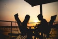 Silhouette of couple lover sitting and relax on romantic sunset at the sea of honeymoon vacation. Royalty Free Stock Photo