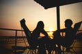 Silhouette of couple lover sitting and relax on romantic sunset at the sea of honeymoon vacation. Royalty Free Stock Photo