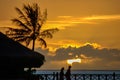 Silhouette of couple and palm tree with golden sunset. Royalty Free Stock Photo