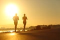 Couple practicing sport running at sunset on the road