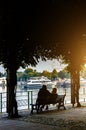 Silhouette couple sitting by the lake. Italy, Arona.