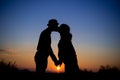 Silhouette of a couple at sunset, kiss, maternity