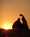 Silhouette of a couple taking selfie on a background of summer sunset Royalty Free Stock Photo