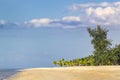 Silhouette of a couple walking along a deserted tropical beach against the sunset sky with clouds Royalty Free Stock Photo