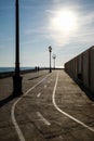 Silhouette of a couple walking along a seaside promenade at sunset Royalty Free Stock Photo