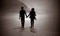 Silhouette of couple walking on a beach. Royalty Free Stock Photo