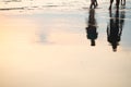 Silhouette of couple walking on beach with drop shadow reflected Royalty Free Stock Photo