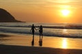 Silhouette of a couple walking on the beach holding hands at dusk Royalty Free Stock Photo