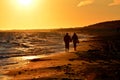 Silhouette of couple walking on beach at sunset holding hands. Horizontally Royalty Free Stock Photo