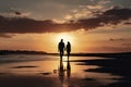 Silhouette of a Couple Walking by the Sea at Sunset: Romantic Beach Stroll Royalty Free Stock Photo