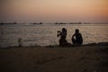 Silhouette of a couple watching colorful sunset on beach Royalty Free Stock Photo