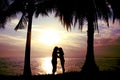 Silhouette couple, woman and man standing and will kissing in front of the sea have coconut tree shadow Royalty Free Stock Photo