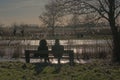 silhouette of a coupleon a bench looking over a winter marsh in the flemish countryside Royalty Free Stock Photo
