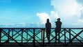 Silhouette of couples on the wooden terrace At Seaside and Sky, Lovers having tender moments summer vacation holidays, Royalty Free Stock Photo