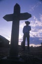 Silhouette of Cowboy next to grave marker at sunset, San Ysidro, CA