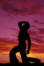 Silhouette cowboy no shirt kneel one knee hand on hat look up