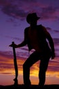 Silhouette of cowboy with shotgun funny pose in sunset