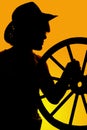 Silhouette of a cowboy and wagon wheel in hand Royalty Free Stock Photo