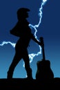 Silhouette of a cowgirl with a guitar by her look to side