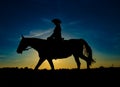 Silhouette cowgirl on horse at sunrise
