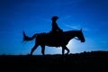 Silhouette cowgirl on horse at sunset in blue 10