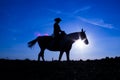 Silhouette cowgirl on horse at sunset in blue 12