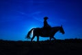 Silhouette cowgirl on horse at sunrise in blue 1
