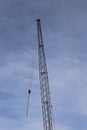 A Silhouette crane on a construction site, with a blue sky. Royalty Free Stock Photo