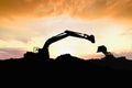 Silhouette Crawler excavator and Wheel loader are digging the soil in the construction site. Royalty Free Stock Photo
