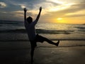 Silhouette of crazy funny happy man gesture on a beach when sunrise