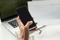 Silhouette of cropped shot of a young man working from home using smart phone and notebook computer, man& x27;s hands Royalty Free Stock Photo