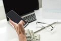 Silhouette of cropped shot of a young man working from home using smart phone and notebook computer, man's hands Royalty Free Stock Photo