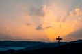 Silhouette of cross on mountain sunset background Royalty Free Stock Photo