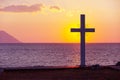 Silhouette of cross at sunrise or sunset with light rays and sea panorama Royalty Free Stock Photo