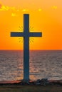 Silhouette of cross at sunrise or sunset with light rays and sea panorama Royalty Free Stock Photo