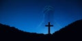 Silhouette of crucifix cross on mountain at night time with hand praying background.