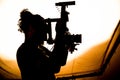 Silhouette of a curly-haired cameraman filming in a studio Royalty Free Stock Photo