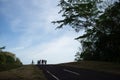 Silhouette of cyclist at the end of an uphill road early in the morning over blue sky Royalty Free Stock Photo