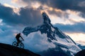 Silhouette of cyclist in front of peak at sunset. Royalty Free Stock Photo